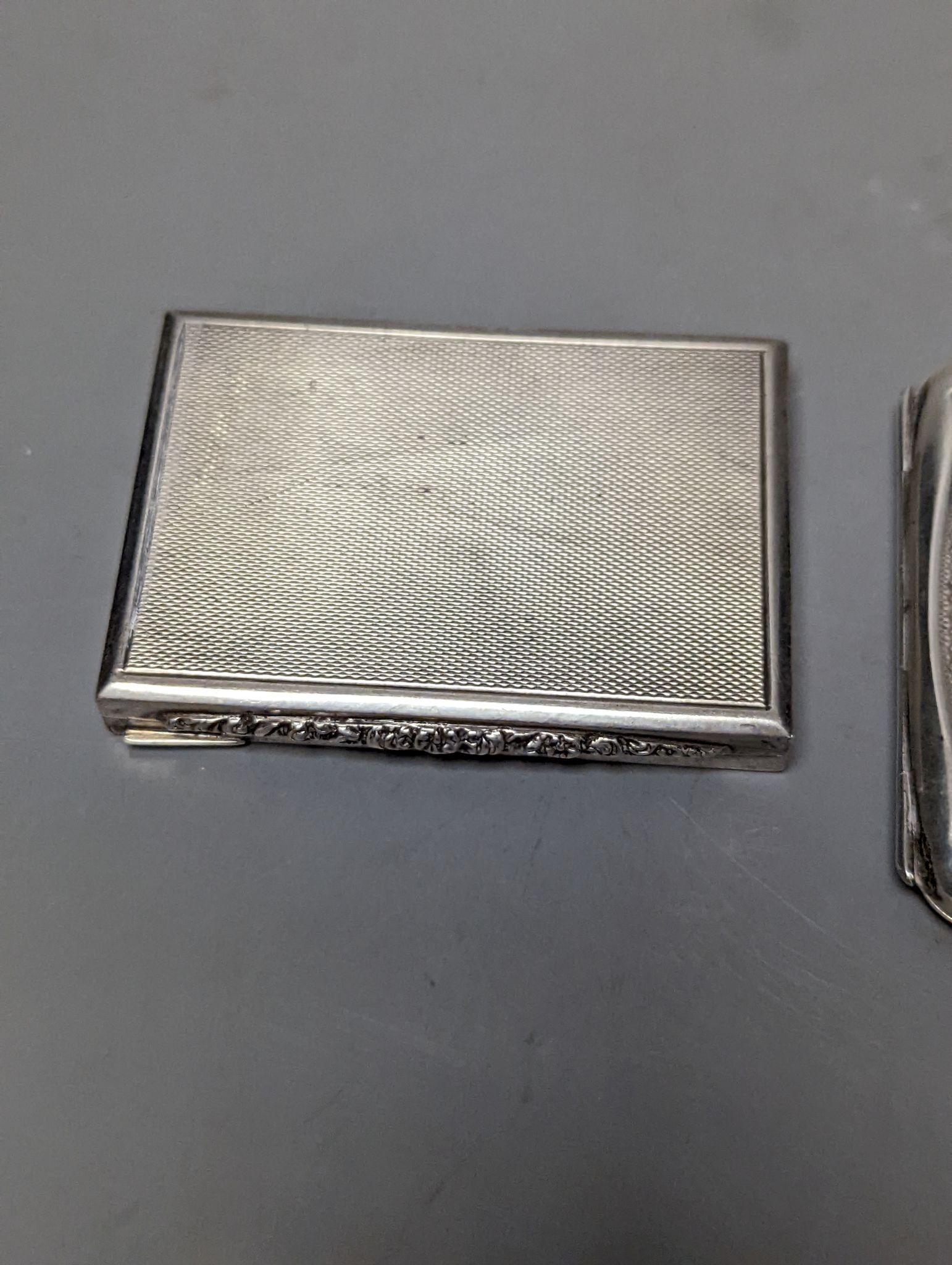 A silver cigarette case, an Austro Hungarian white metal box and a silver cigarette case with panel decorated with a topless lady, 77mm, gross weight 172 grams.